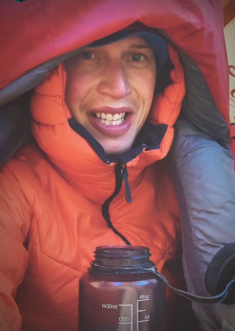 Jost Kobusch in a tent, overed in several layers of warm, high-altitude clothes. 