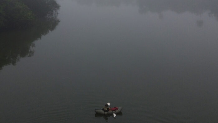 a man paddles a boat on a large river