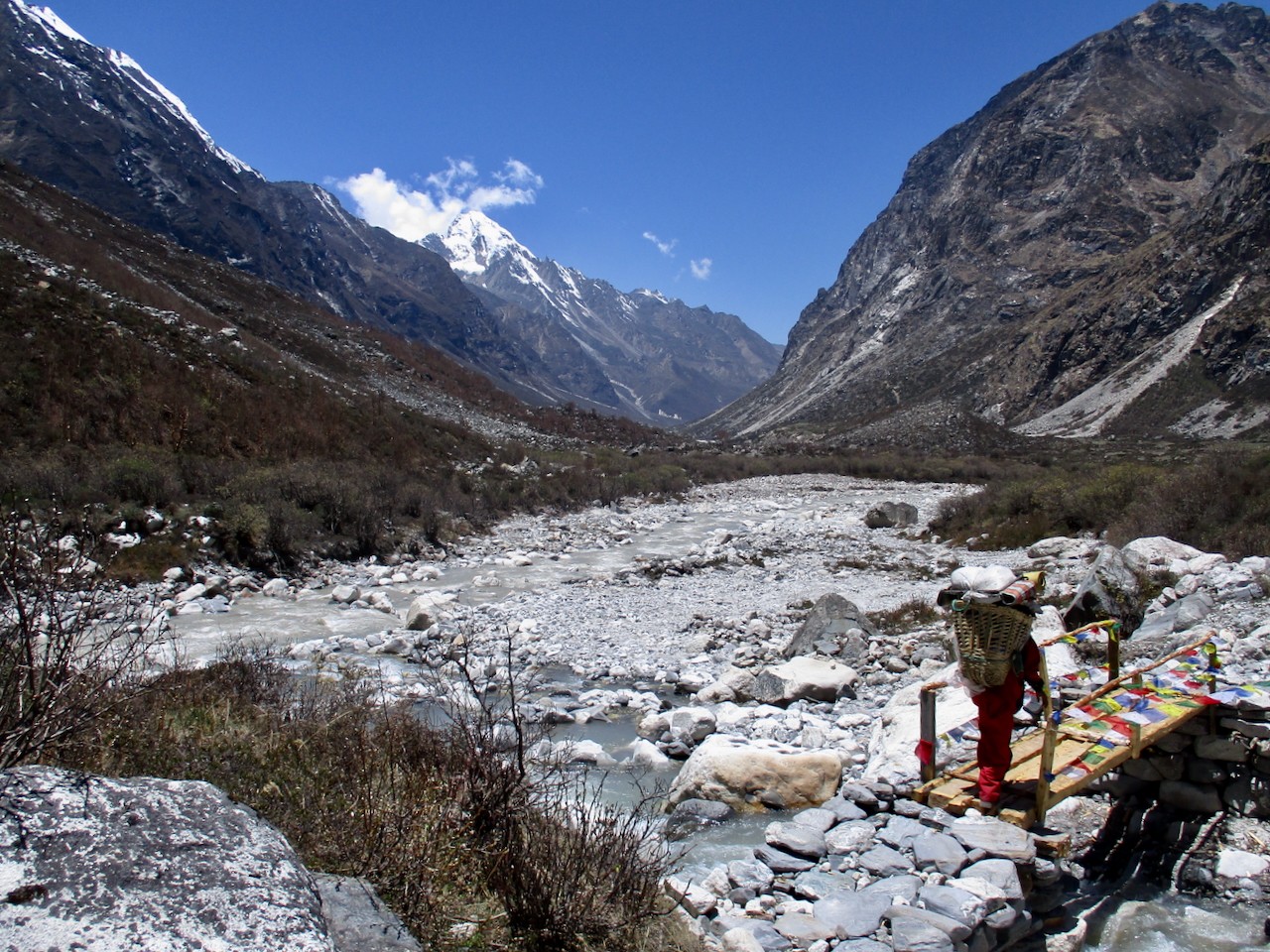 A porter crosses a bridge in Langtang.