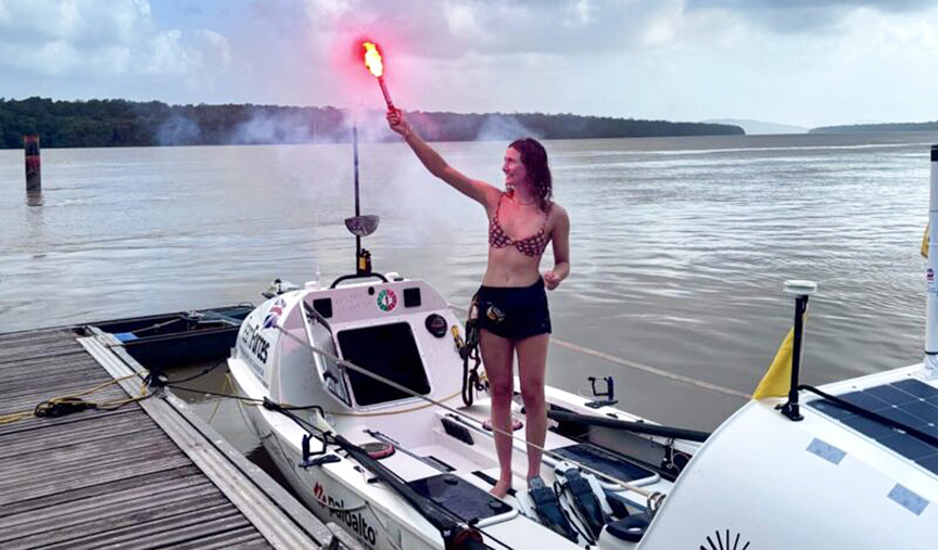 woman standing on dock with lit flare.