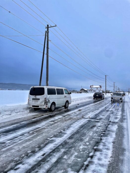 a van at the side of a icy road, with a bump on its rear