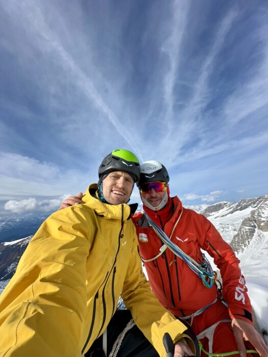 two climbers on a summit take a selfie