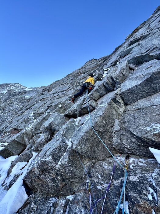 A climber on a mixed face with overhanging slabs