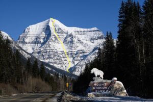 The south face of mount Robson, british Columbia, as seen from a road with a photo point. A ski line is marked in yellow on the face.