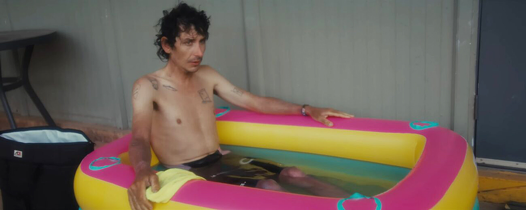 A man in an inflatable tub, looking haggard