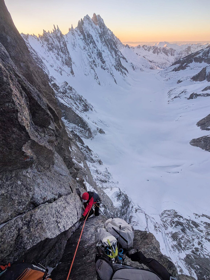 The climber on a north face in the alps, progressing on 