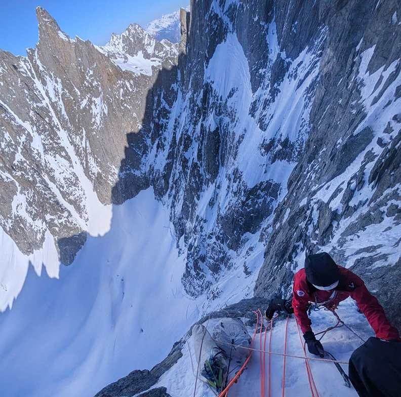 A climber at a belay on a mixed route in the Alps