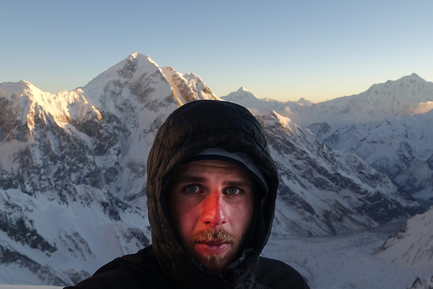 Yanick Ueltschi: close shot of his face at sunset with mountains behind