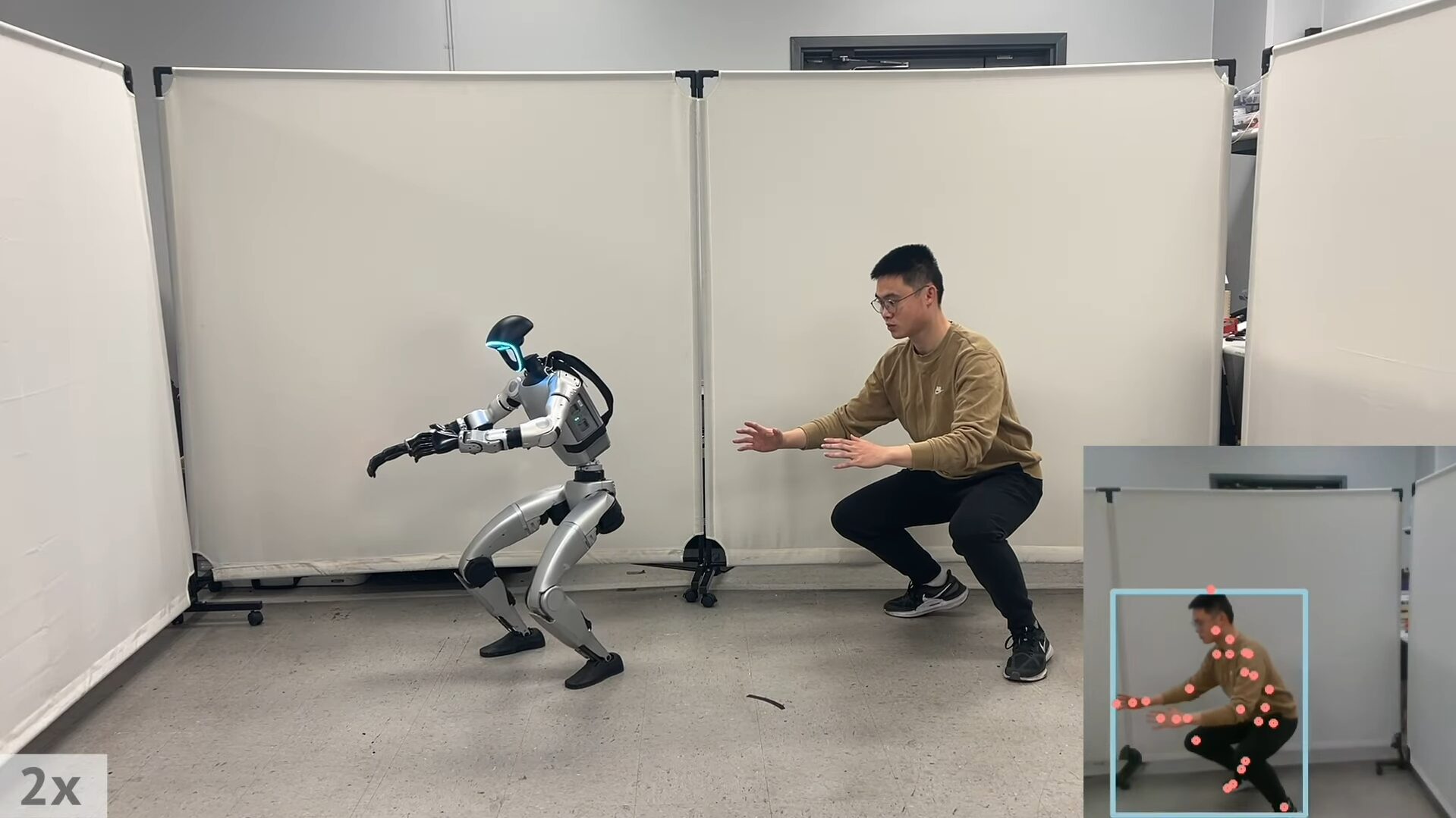 A robot crouching in front of a man performing the same motion.