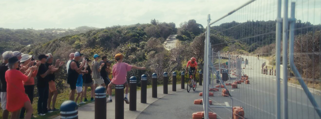 A man cycling, with a crowd watching.