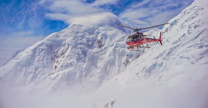 A helicopter approaches climbers in need of rescue on Denali