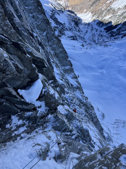 A climber as seen from above, in a shadowy north face of Tyrol