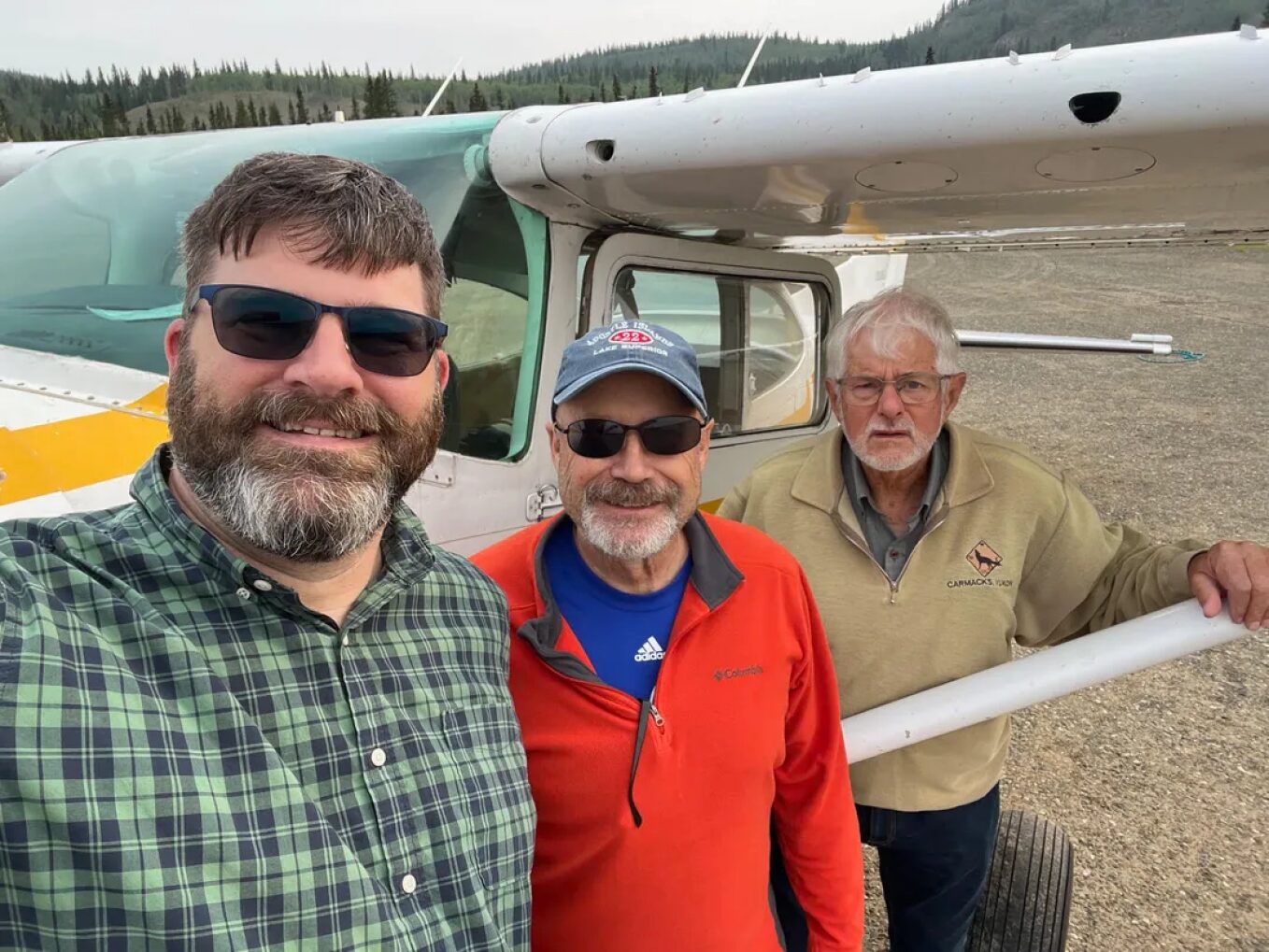 Three men in front of a small plane in the Yukon