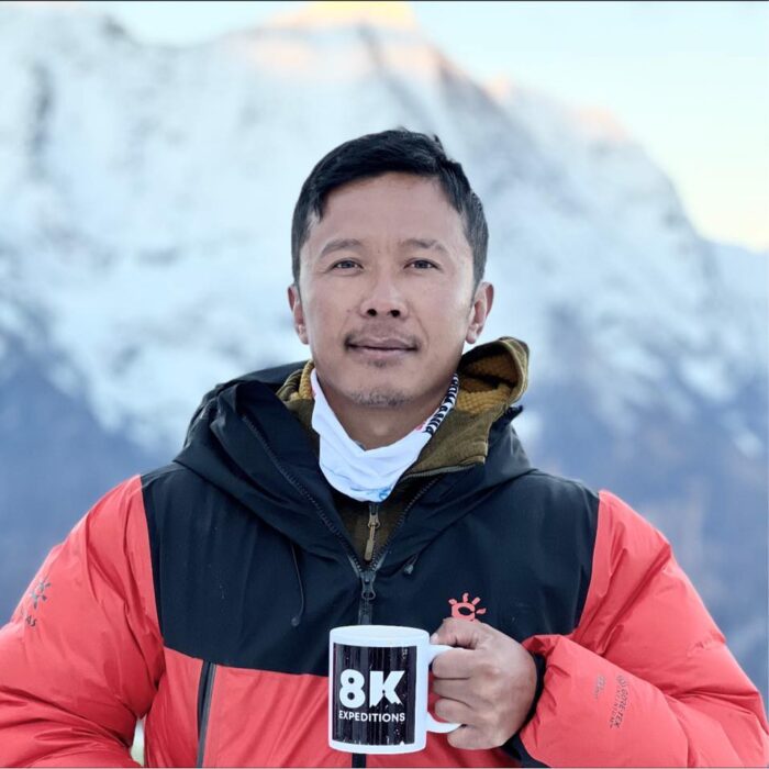 Close shot of Lakpa Sherpa with a corporate mug of tea at a Base Camp. 