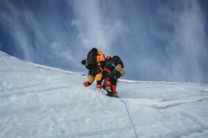 Tho sherpa climbers on a steep slope on Annapurna, climb on a fixed rope.