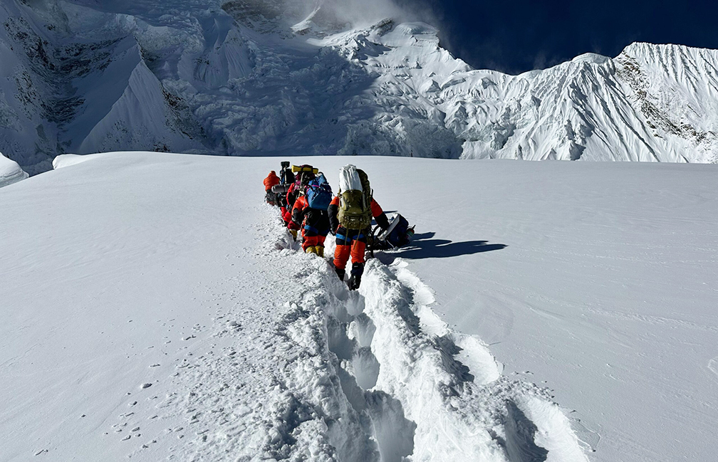 Sherpas breaking trail in deep fresh snow on a plateau at Annapurna