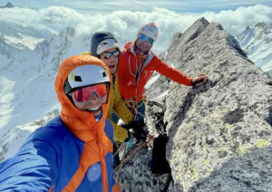 three climbers on a stony summit