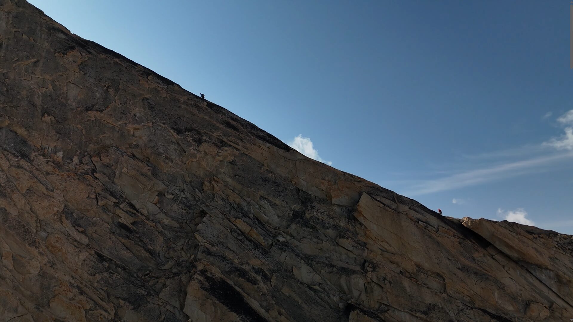 A ridge with a climber on top of it.