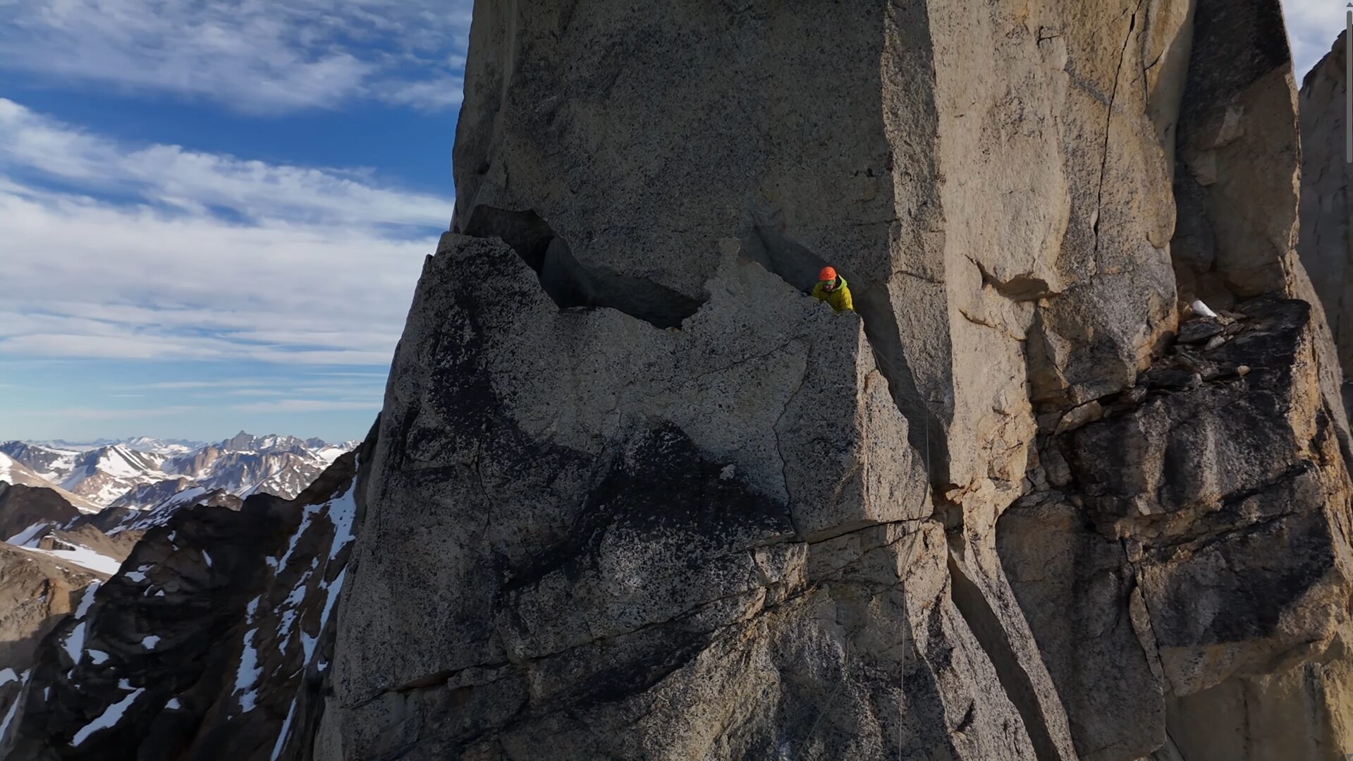 A shot of a man in a crack in the rock.