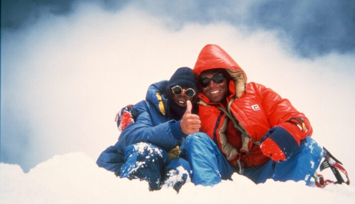 Climbers on a snowy summit, dressed in 1980's mountain clothes