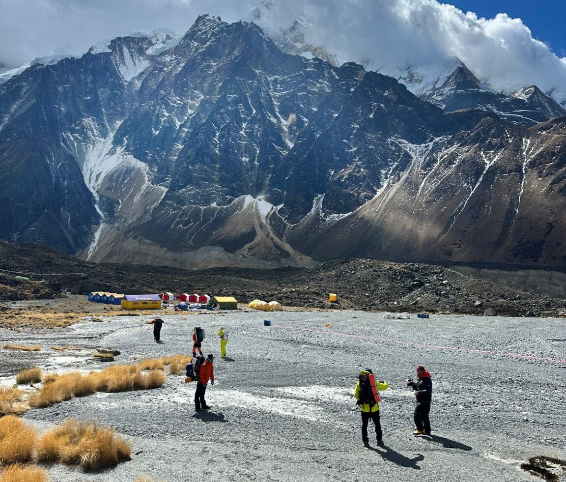 Some people on a flat area in front of a very dry Annapiurna