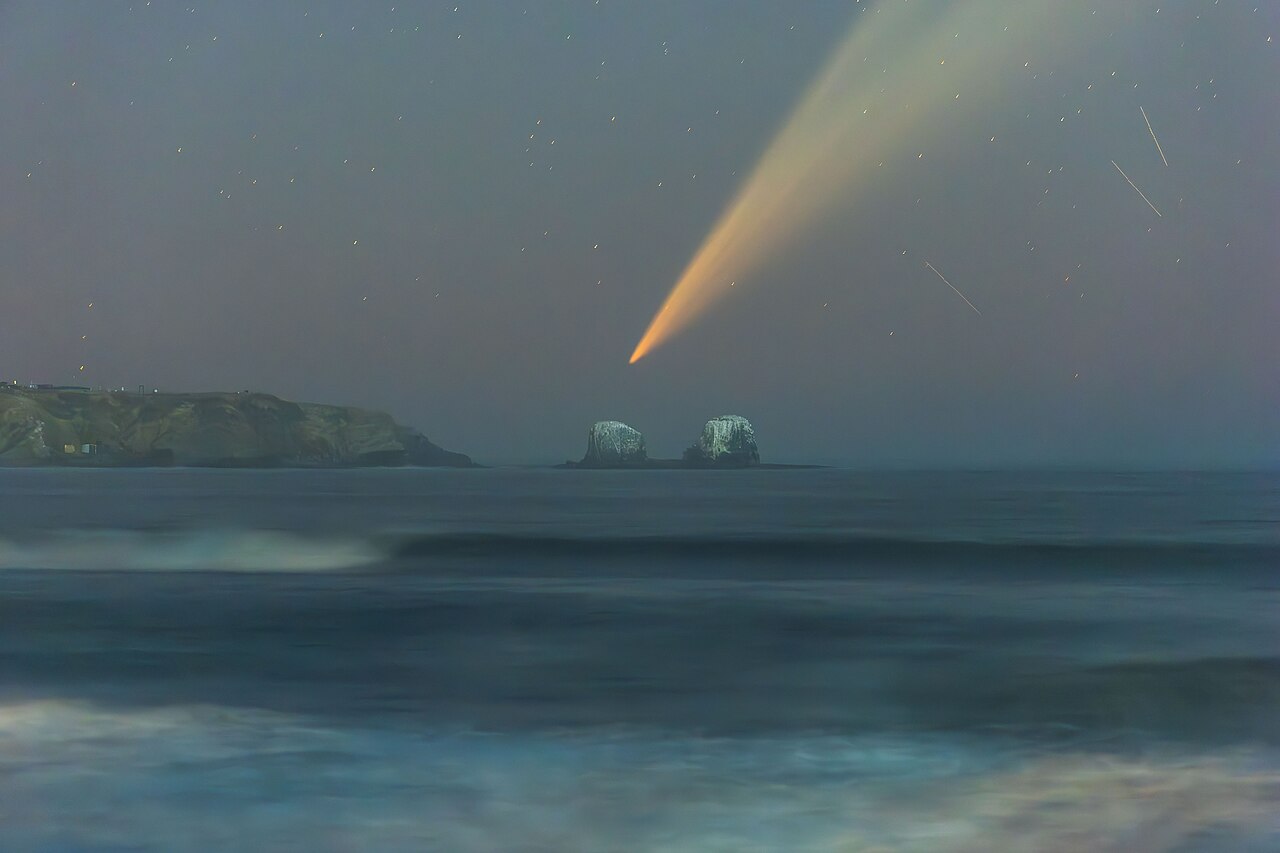 A comet descending over the ocean.