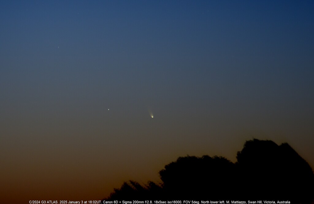 A photo of a faint comet in a sunset sky.