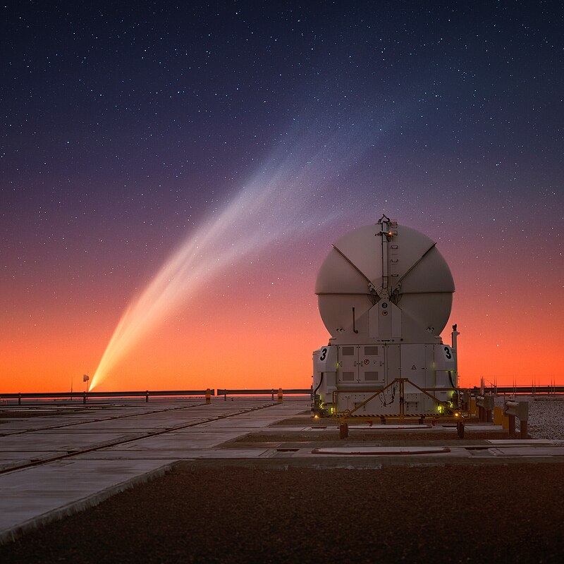 A photo of the comet behind a telescope.