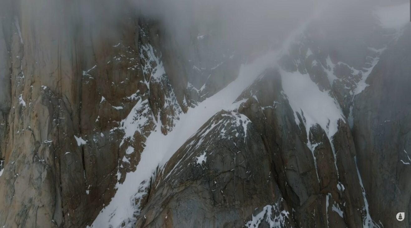 A thin band of snow diagonal across a granite mountainside