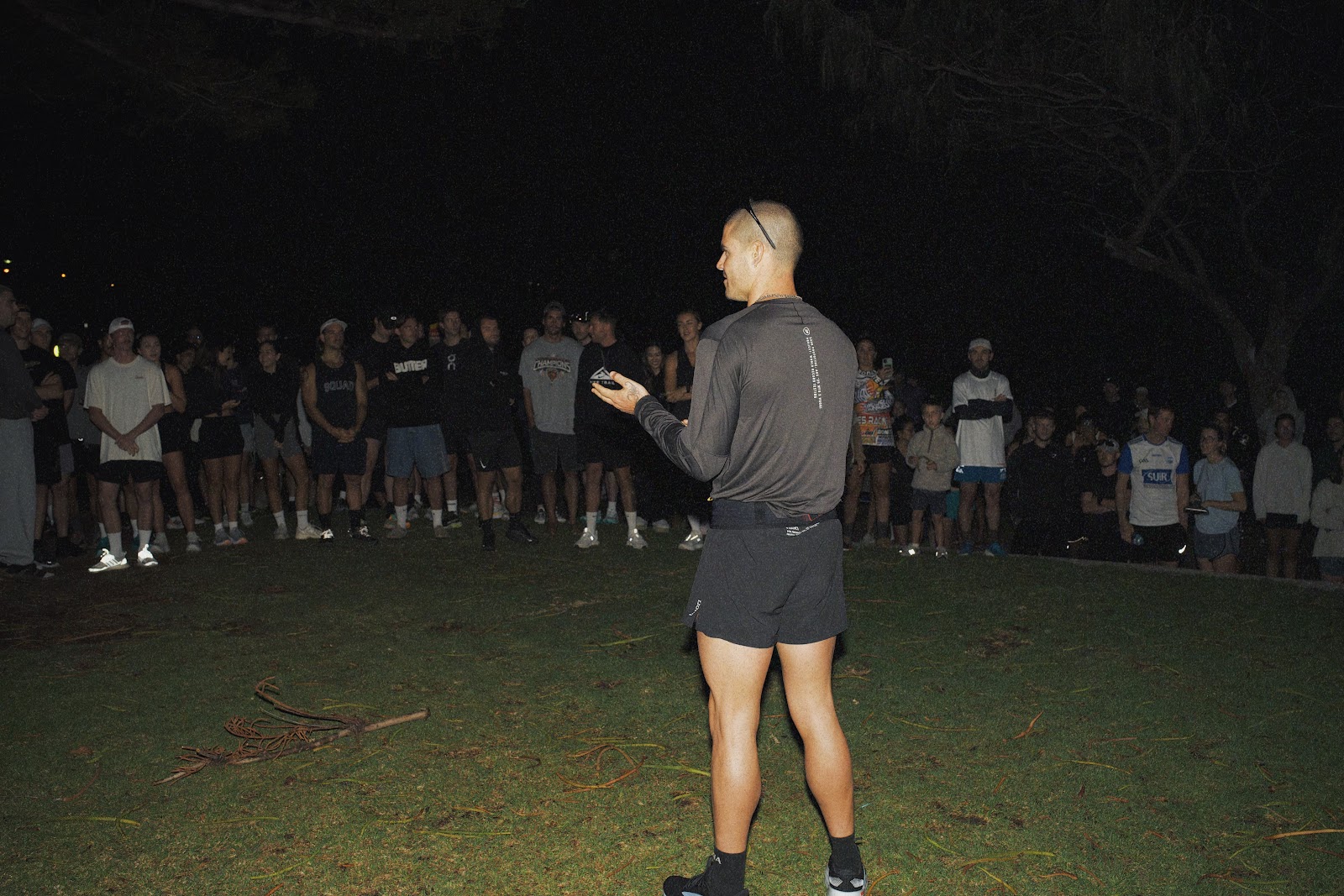 A man standing in front of a crowd at night