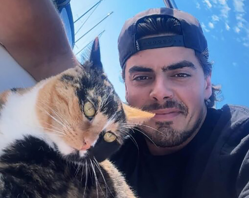 man and cat on sailboat