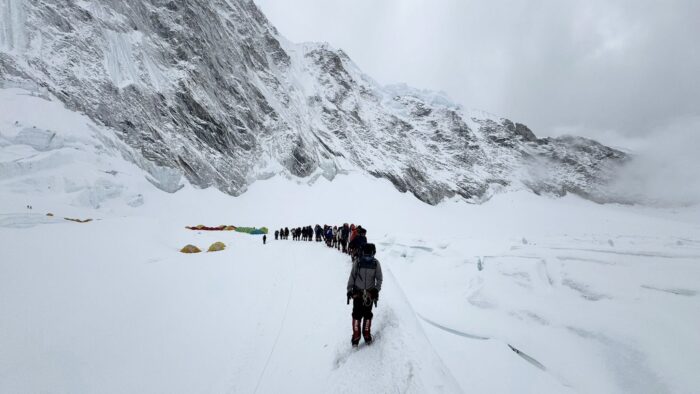 A line of climbers marching towards Camp 2 on Everest in a foggy day