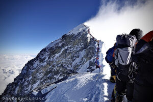 Climbers queue along the summit ridge of Everest, in high winds.