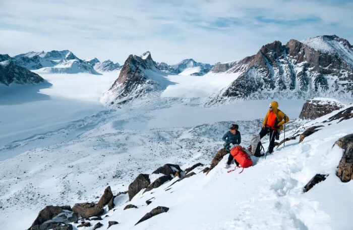 Two climbers rest on a moderate slope on a mountain on Baffin Island
