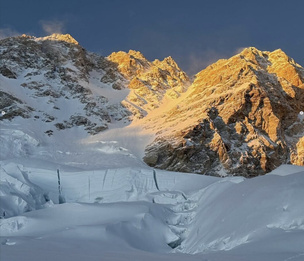 The summit area of Kangchenjunga in the evening light, with mixed sections, big seracs and wind on the summit ridge.