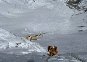 Climbers on a fixed ropes on the Lhotse Face with camp 3 tents below them, as they head for the Camp 4 of Everest.