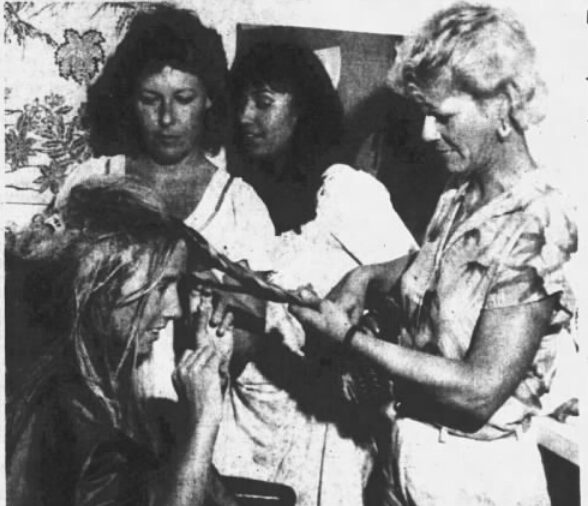 A woman brushing another woman's hair, both smiling