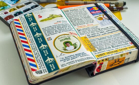 An open notebook filled with stickers, stamps and handwritten text