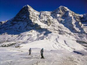Skiers on slopes with Eiger in Background, Swill Alps.