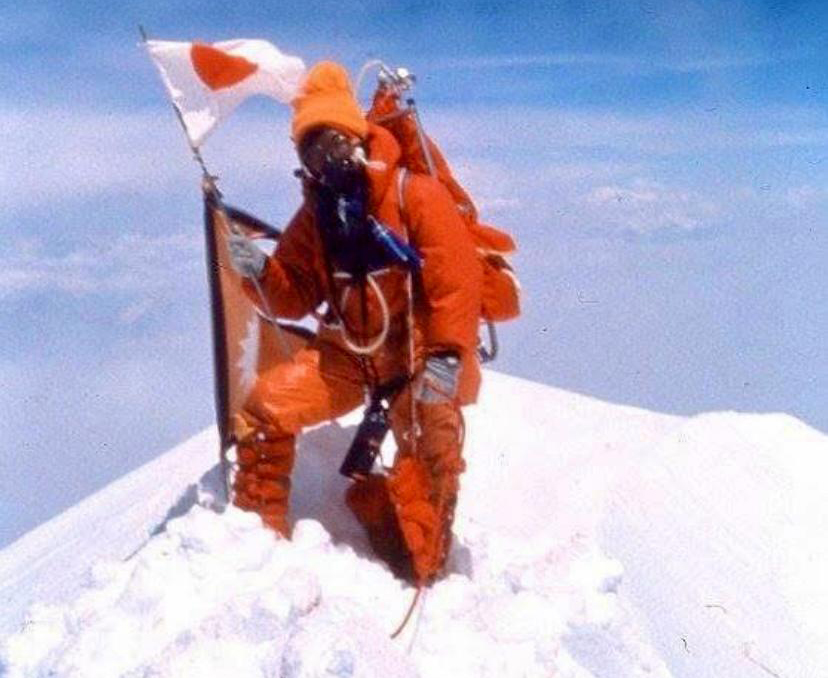 woman on mountaintop with Japanese flag