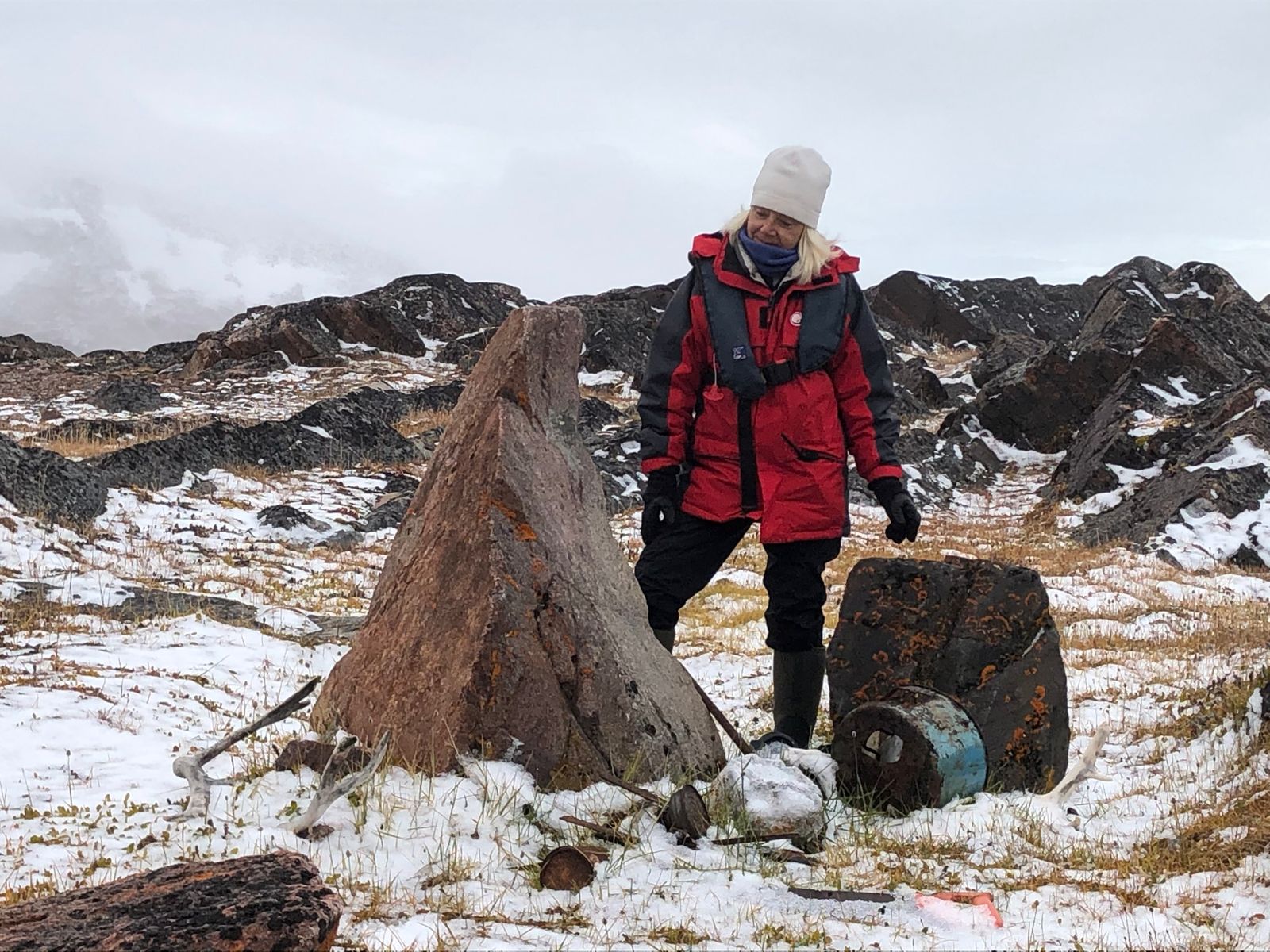 triangular rock with women in red parka