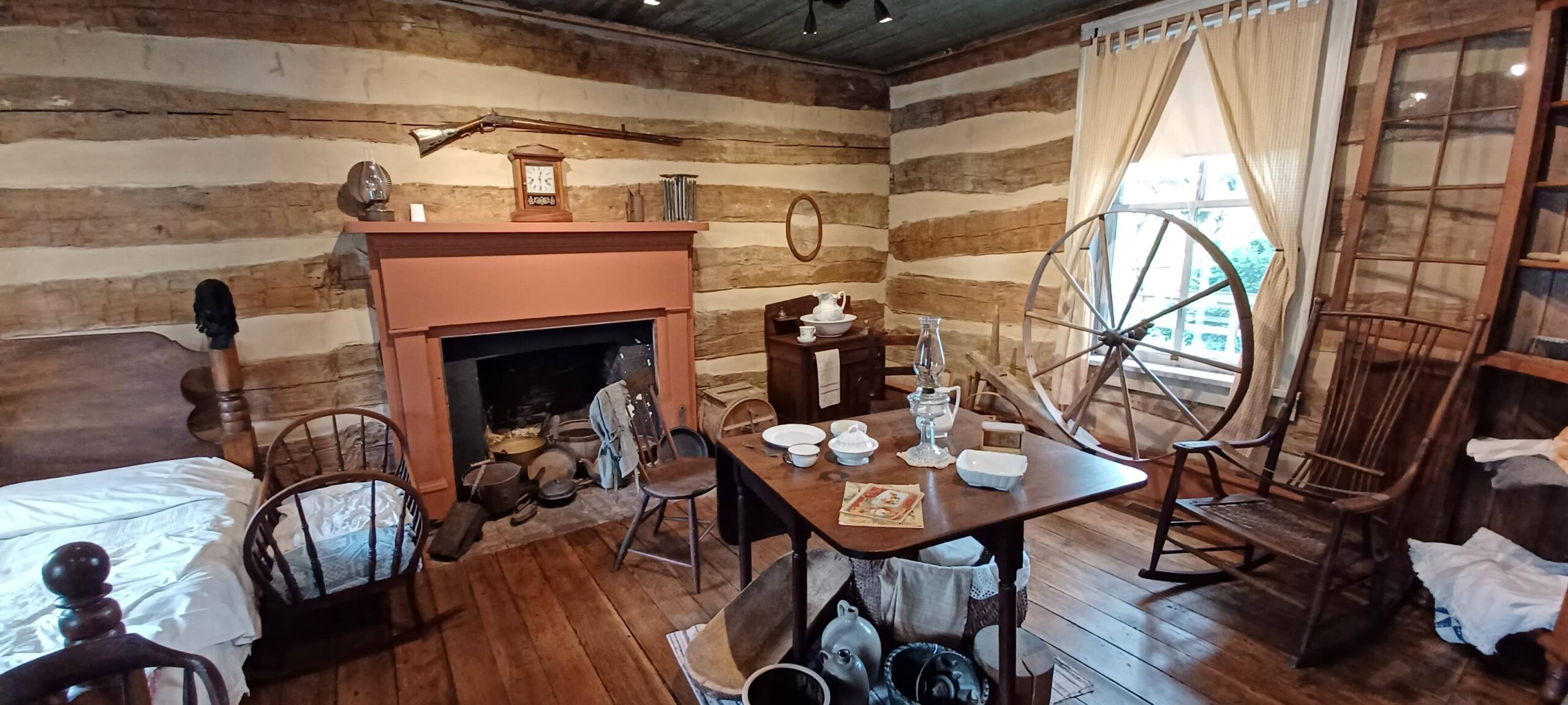 An old fashioned room with a spinning wheel in it.