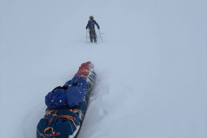 An arctic traveler pulling a sled in deep snow on Ellesmere Island.