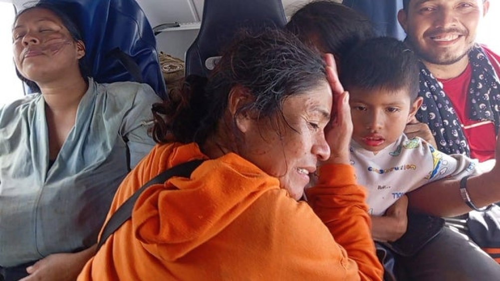 Five people-- three women, a small child and a man-- sitting in a helicopter.
