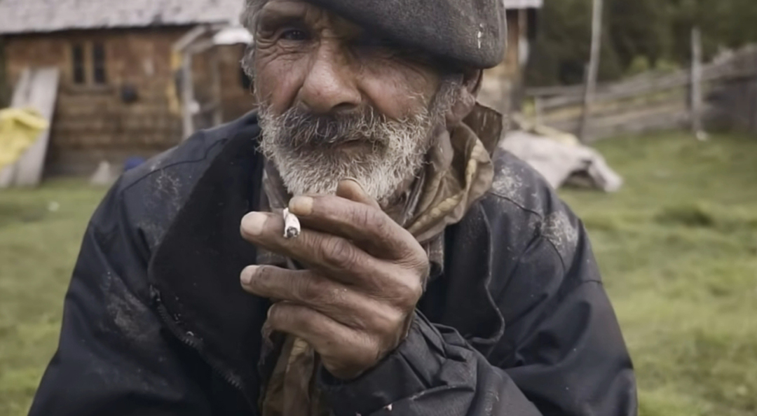 An old man smoking a hand-rolled cigarette