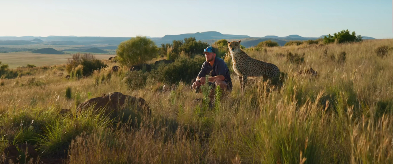 man sitting with cheetah