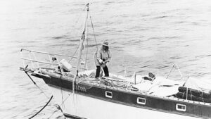 A woman on a small sail boat at sea