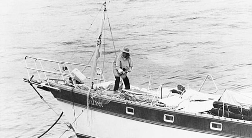 A woman on a small sail boat at sea