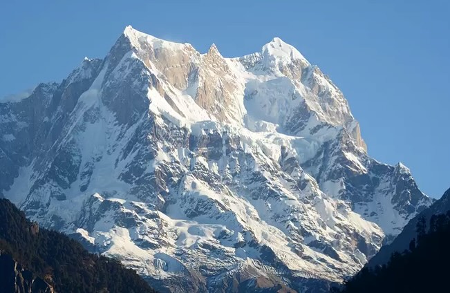 A rock and ice mountain with a long summit ridge and three main points.