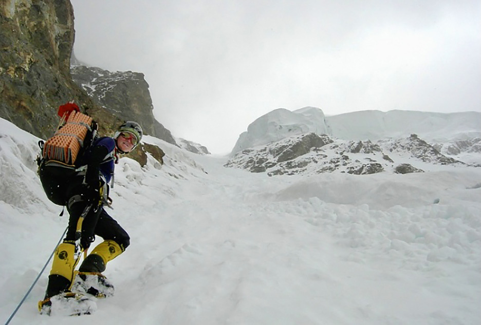 woman climber looks down on ovecast snowy day